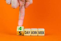 Un dedo señala dados con las palabras 4 day work week