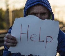 Persona con cartel con la palabra 'help' ayuda en inglés